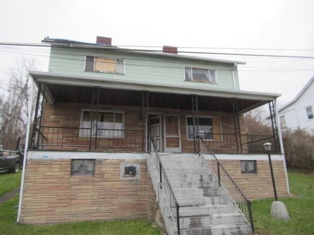 view of front facade with covered porch and a front lawn