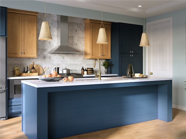 kitchen with light wood-type flooring, wall chimney range hood, and hanging light fixtures