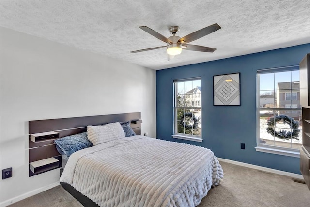 bedroom featuring a textured ceiling, carpet floors, and ceiling fan