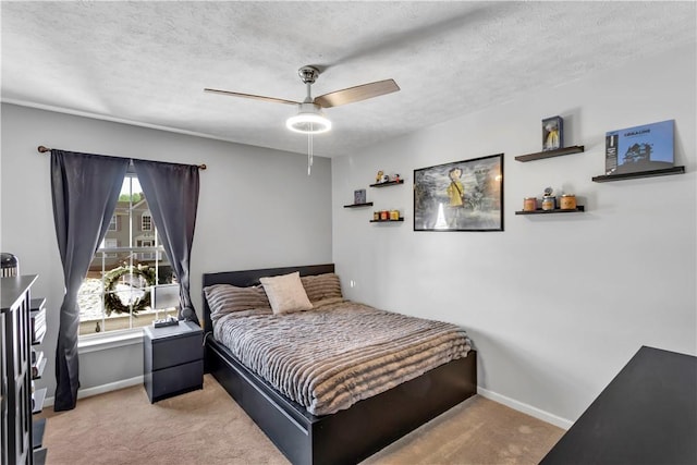 carpeted bedroom featuring ceiling fan and a textured ceiling