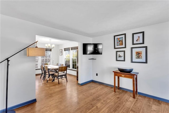 dining space with hardwood / wood-style floors and a notable chandelier