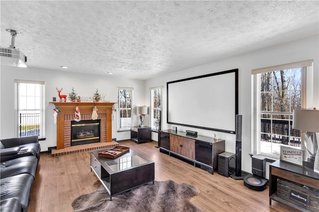 home theater featuring a healthy amount of sunlight, wood-type flooring, and a textured ceiling