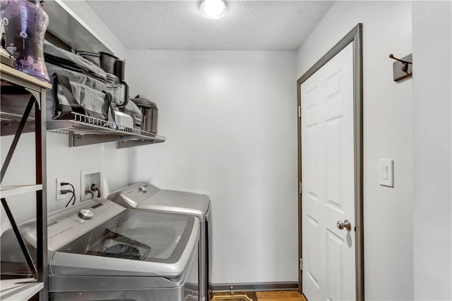 clothes washing area featuring washing machine and dryer and a textured ceiling