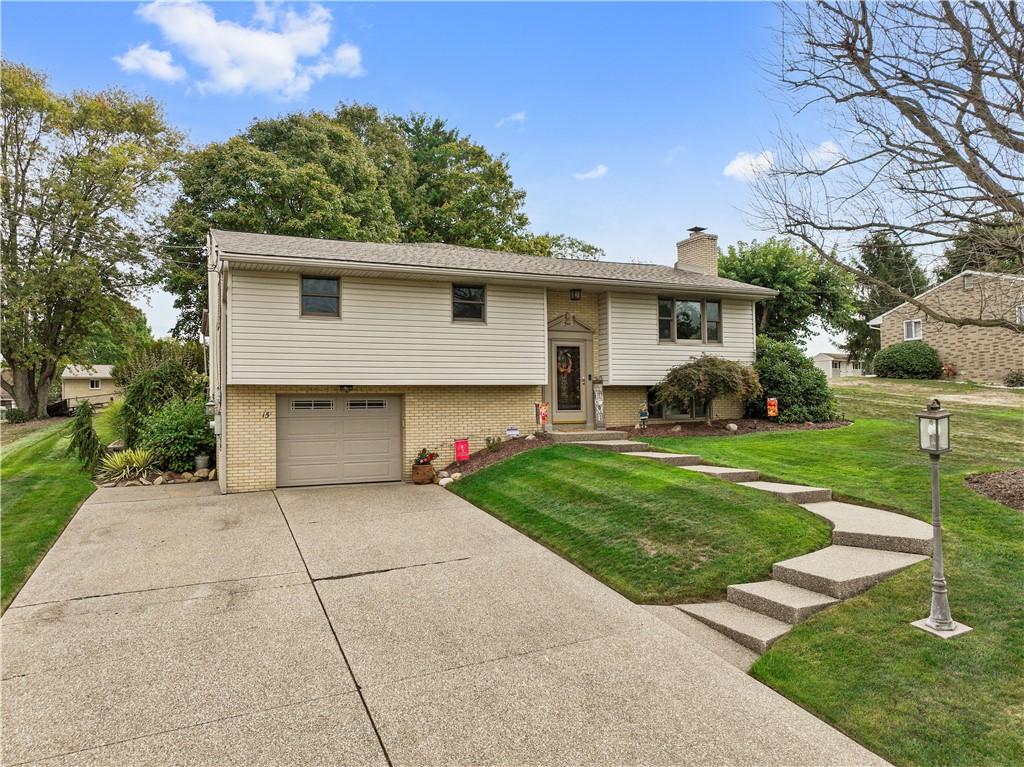 bi-level home with a garage and a front lawn