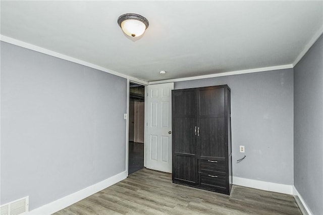 unfurnished bedroom featuring light hardwood / wood-style flooring and crown molding