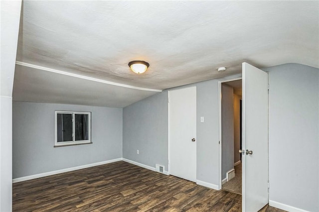 bonus room with dark wood-type flooring and lofted ceiling