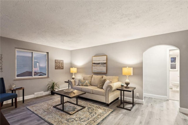 living room with wood-type flooring and a textured ceiling