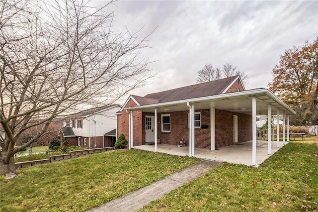 rear view of house with a carport and a lawn