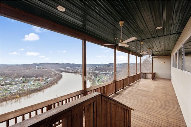 wooden deck featuring a water view and ceiling fan