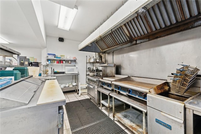 kitchen with stainless steel range and light tile patterned floors