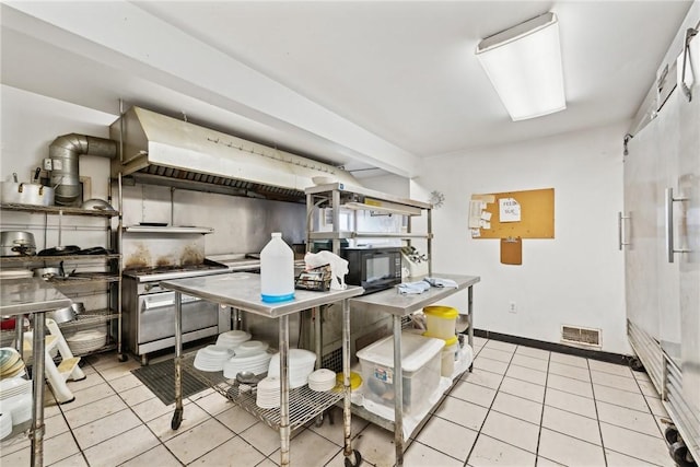 kitchen featuring light tile patterned flooring and high end stainless steel range oven