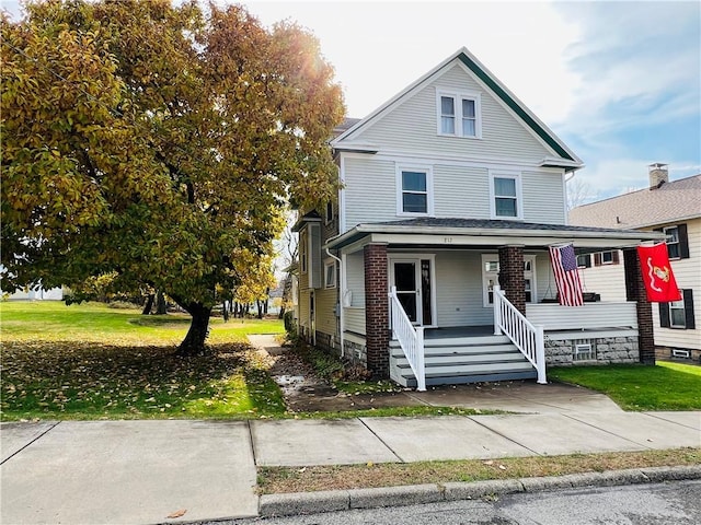 view of front facade featuring a front lawn and covered porch