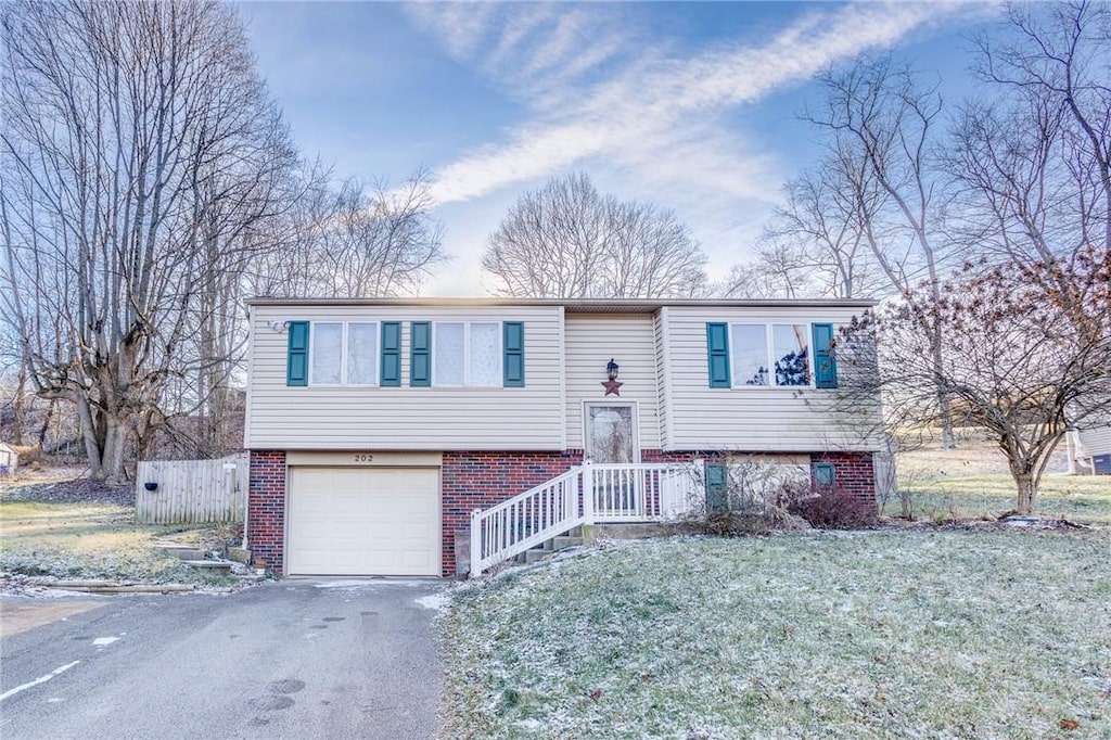 bi-level home with a front yard and a garage