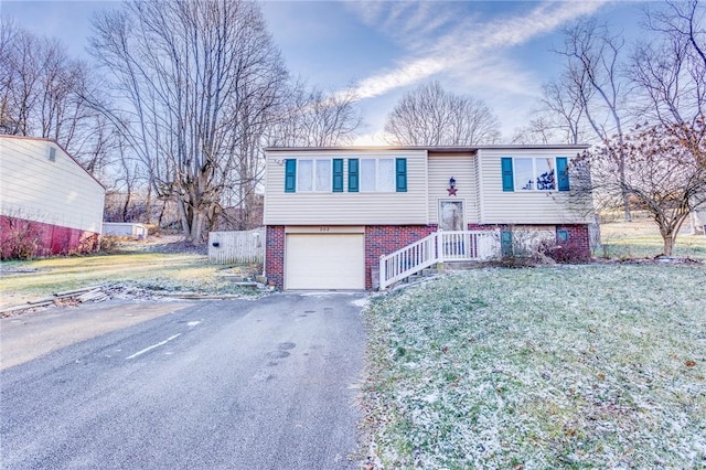 bi-level home with a garage and a front yard