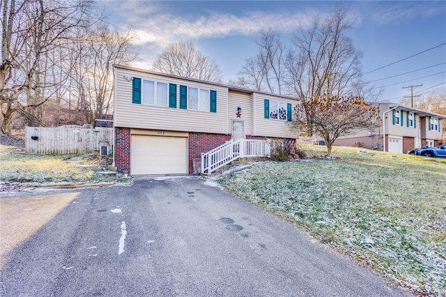 bi-level home with a front yard and a garage