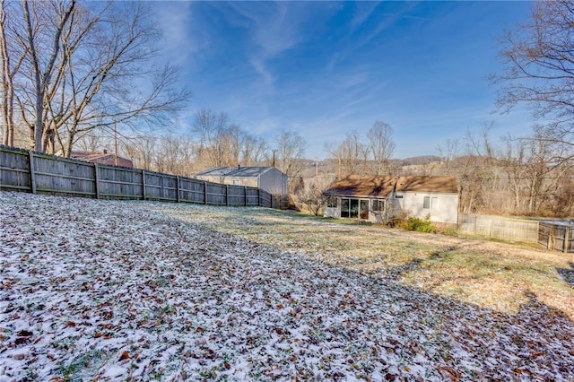 yard covered in snow with an outbuilding