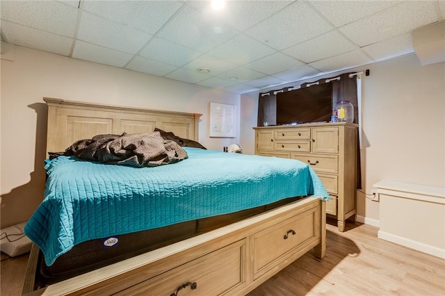 bedroom featuring a paneled ceiling and light hardwood / wood-style flooring