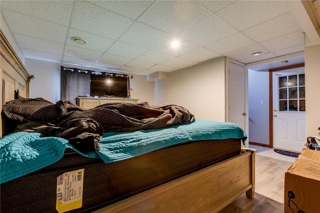 bedroom with a drop ceiling and hardwood / wood-style flooring