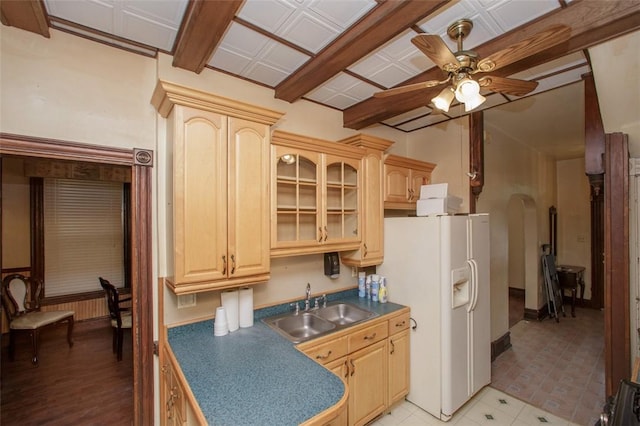 kitchen featuring white refrigerator with ice dispenser, sink, ceiling fan, light wood-type flooring, and light brown cabinetry