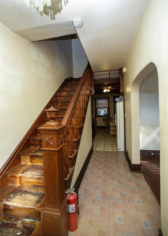 stairway with tile patterned floors and ceiling fan