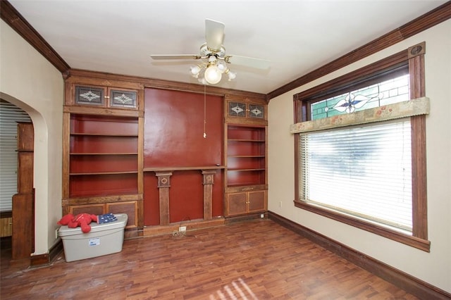 unfurnished office with ceiling fan, dark wood-type flooring, and ornamental molding