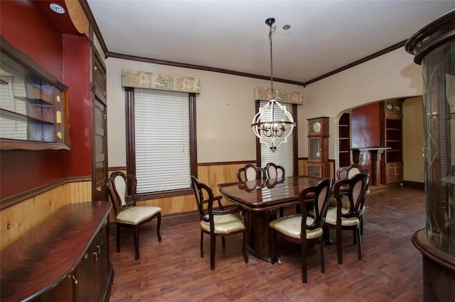 dining area featuring crown molding, dark hardwood / wood-style flooring, and a chandelier