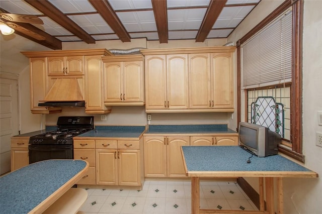 kitchen with black gas range, light brown cabinets, ceiling fan, beamed ceiling, and custom range hood