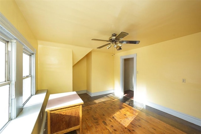 empty room with ceiling fan and dark hardwood / wood-style flooring