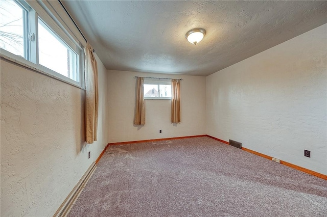 carpeted spare room with a textured ceiling