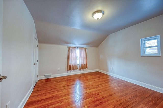 additional living space featuring lofted ceiling and light wood-type flooring