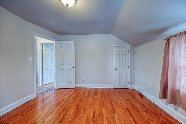 additional living space featuring light hardwood / wood-style floors and lofted ceiling