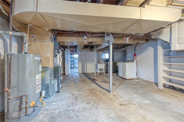 basement with gas water heater, washer / clothes dryer, heating unit, and sink