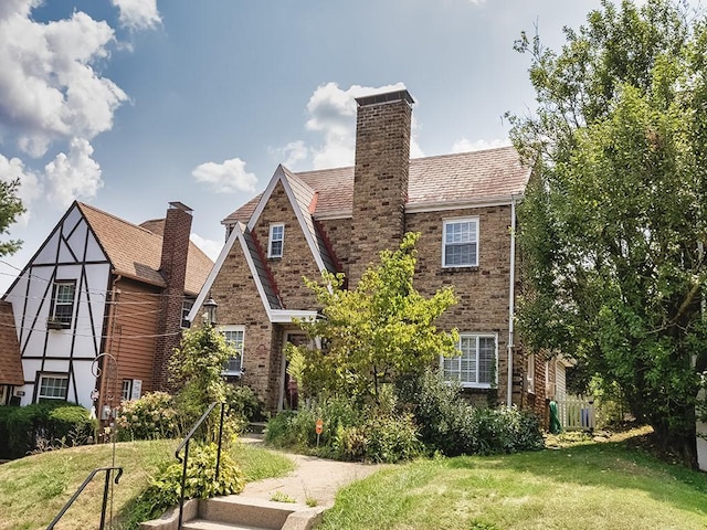 tudor-style house featuring a front yard