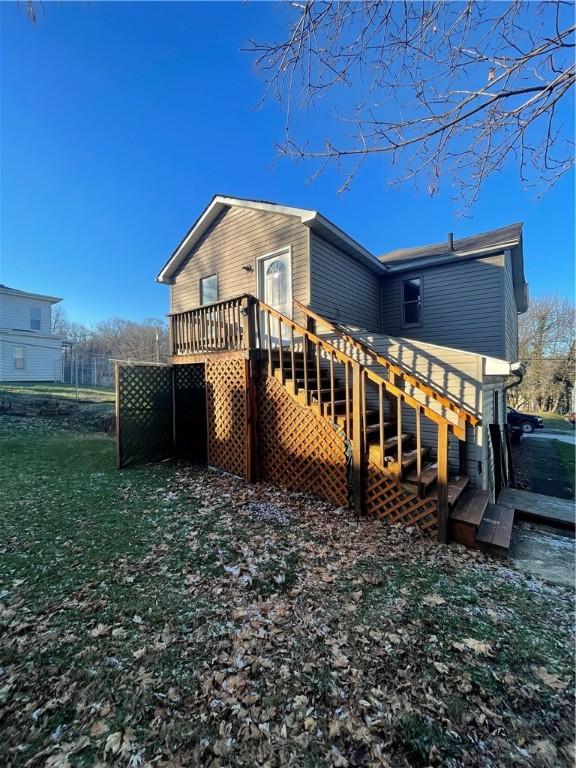 rear view of property with a yard and a wooden deck