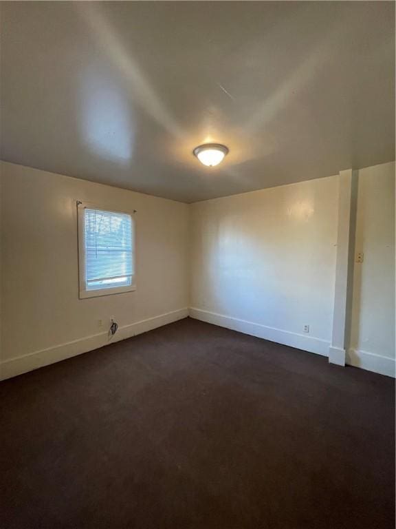 empty room featuring dark carpet