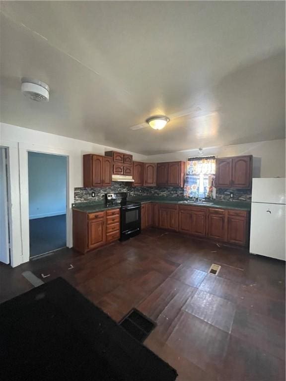 kitchen with backsplash, electric range, sink, and white refrigerator