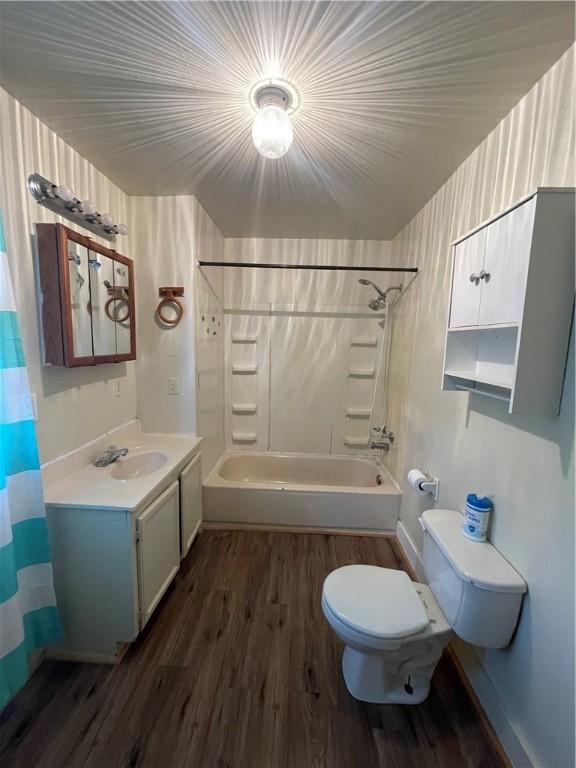 full bathroom featuring hardwood / wood-style floors, vanity, toilet, and shower / bath combo