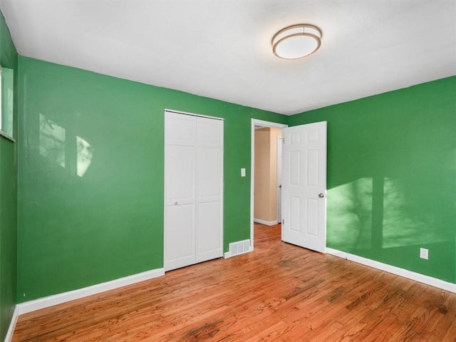 unfurnished bedroom with a closet and light hardwood / wood-style flooring