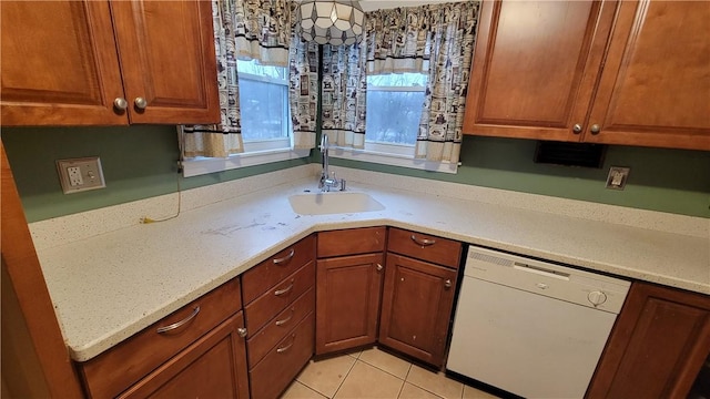 kitchen featuring light stone counters, light tile patterned floors, sink, and dishwasher