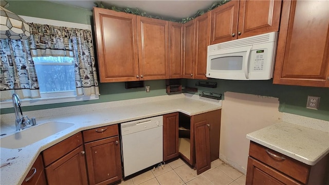 kitchen featuring light stone counters, sink, white appliances, and light tile patterned floors