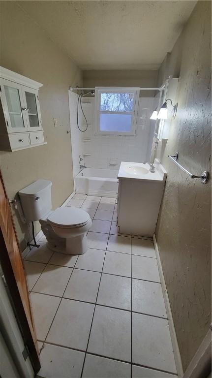 full bathroom with tiled shower / bath, vanity, toilet, and tile patterned flooring