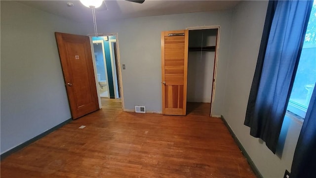 unfurnished bedroom featuring hardwood / wood-style floors and a closet