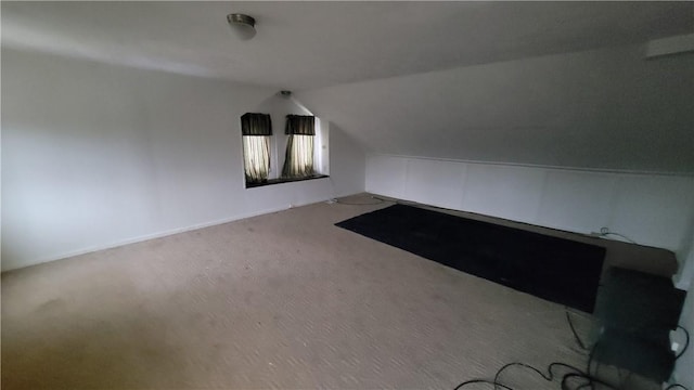 bonus room with vaulted ceiling and carpet