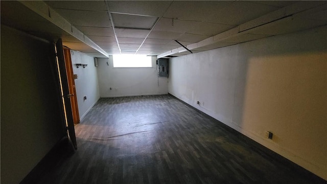 basement featuring dark hardwood / wood-style flooring and a paneled ceiling