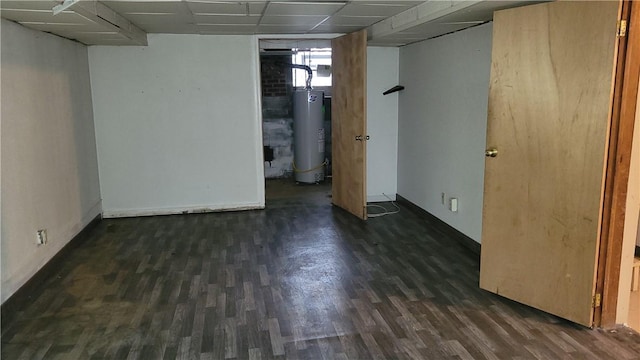 basement featuring gas water heater, dark hardwood / wood-style floors, and a drop ceiling