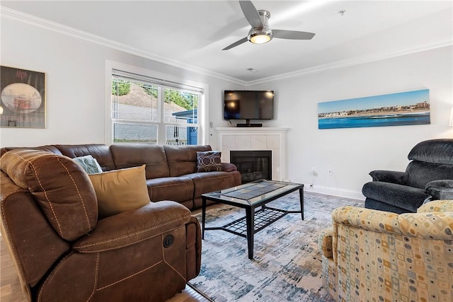 living room featuring a tile fireplace, crown molding, ceiling fan, and light hardwood / wood-style floors