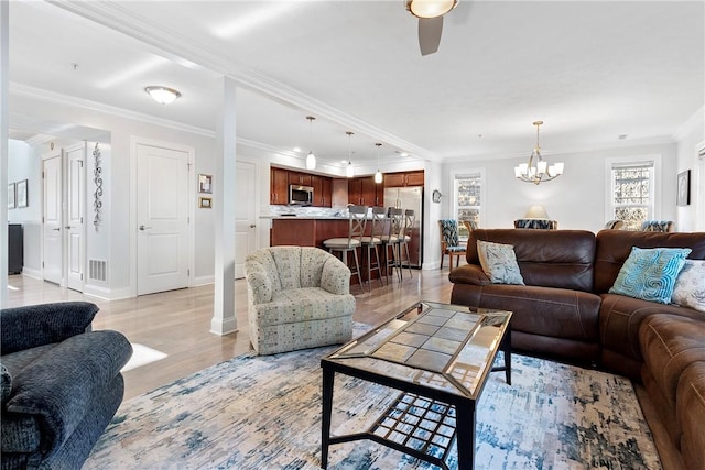 living room featuring ceiling fan with notable chandelier, light hardwood / wood-style flooring, and ornamental molding