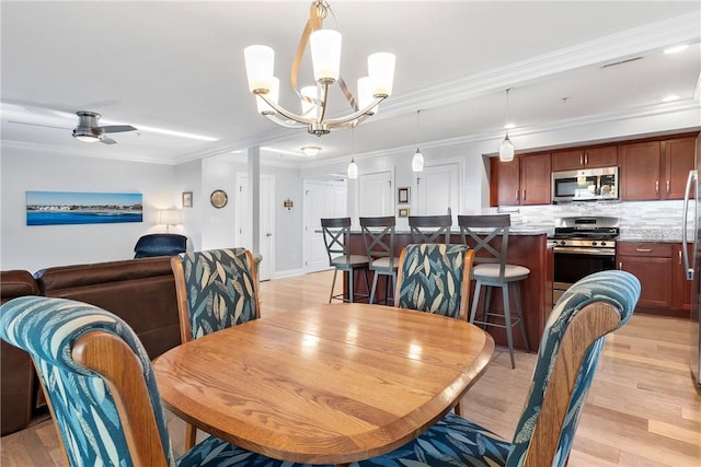 dining space with ceiling fan with notable chandelier, light hardwood / wood-style floors, and ornamental molding