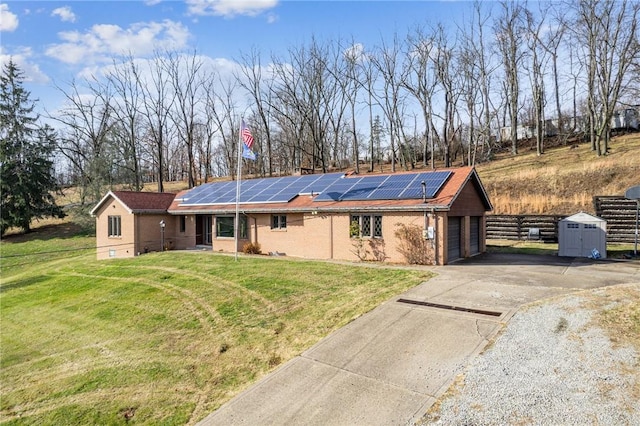 ranch-style house with solar panels, a garage, and a front lawn