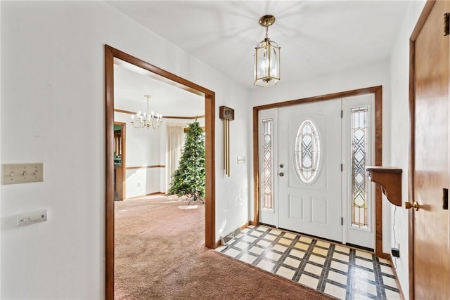 carpeted foyer featuring an inviting chandelier